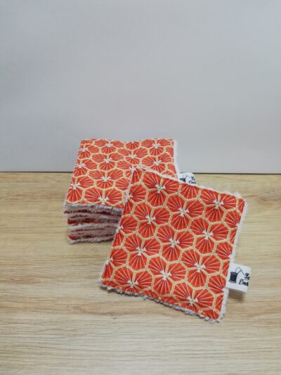 photo d'un lot de 10 lingettes, avec une face en éponge douce blanche et l'autre face en coton orange avec motifs géométriques