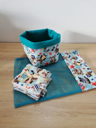 photo d'un kit lingettes composé d'un lot de 10 lingettes, d'un filet de lavage et d'une panière, confectionné avec le même coton bleu ciel motifs animaux pirates