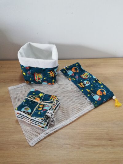 photo d'un kit lingettes composé d'un lot de 10 lingettes, d'un filet de lavage et d'une panière, confectionné avec le même coton bleu/vert motifs dinosaures de l'espace