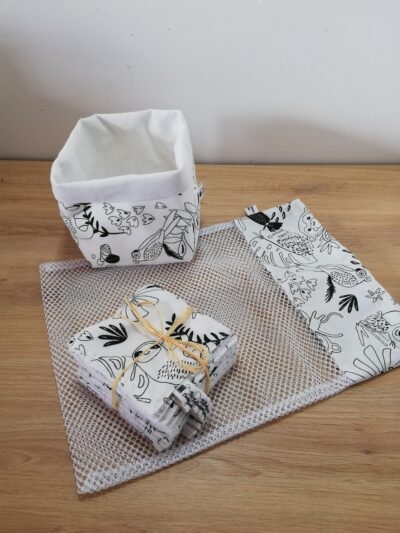 photo d'un kit lingettes composé d'un lot de 10 lingettes, d'un filet de lavage et d'une panière, confectionné avec le même coton blanc et noir motif jungle