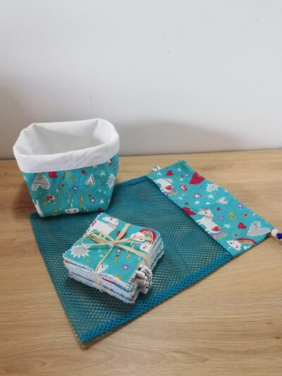 photo d'un kit lingettes composé d'un lot de 10 lingettes, d'un filet de lavage et d'une panière, confectionné avec le même coton bleu motifs licornes et coeurs