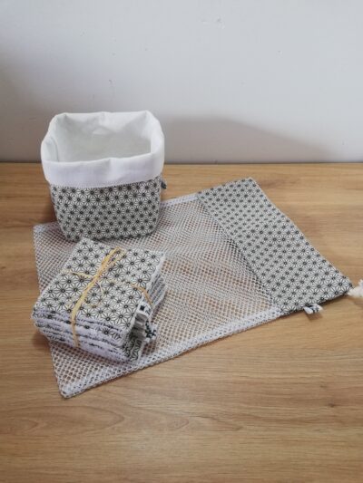 photo d'un kit lingettes composé d'un lot de 10 lingettes, d'un filet de lavage et d'une panière, confectionné avec le même coton aux motifs géométriques blanc, noir et taupe