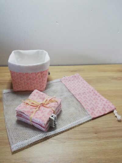 photo d'un kit lingettes composé d'un lot de 10 lingettes, d'un filet de lavage et d'une panière, confectionné avec le même coton rose aux motifs géométriques