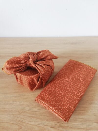 photo d'un furoshiki caramel avec motifs vagues, noué